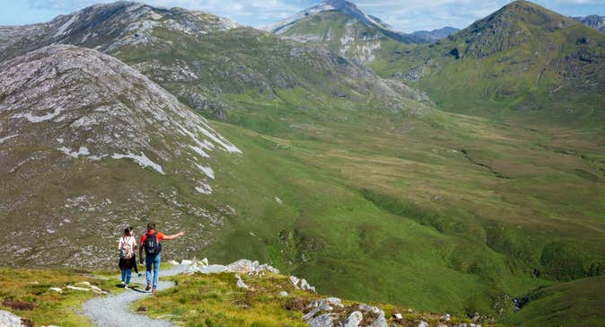 Couple walking with mountains facing them