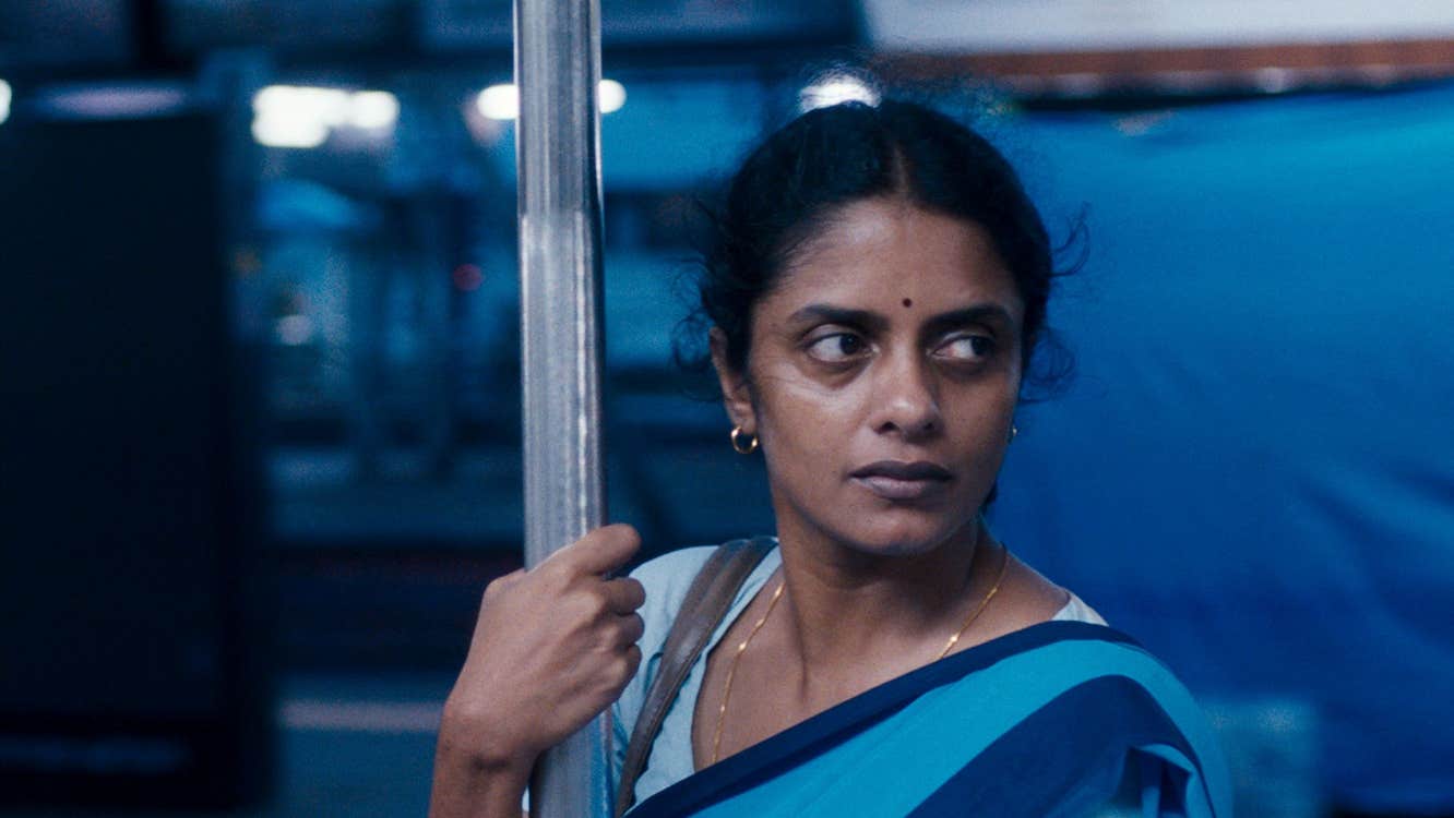 A worried Indian woman is on a train.