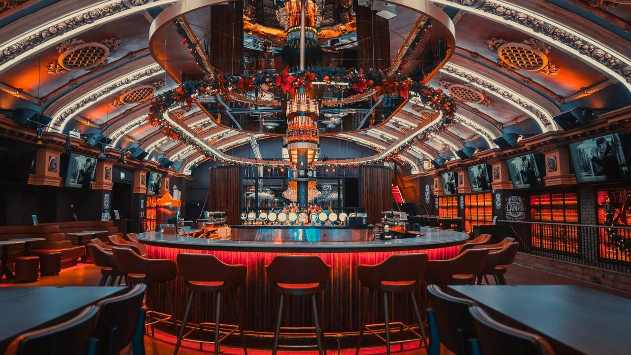 An illuminated circular bar featuring vaulted ceilings with architectural details