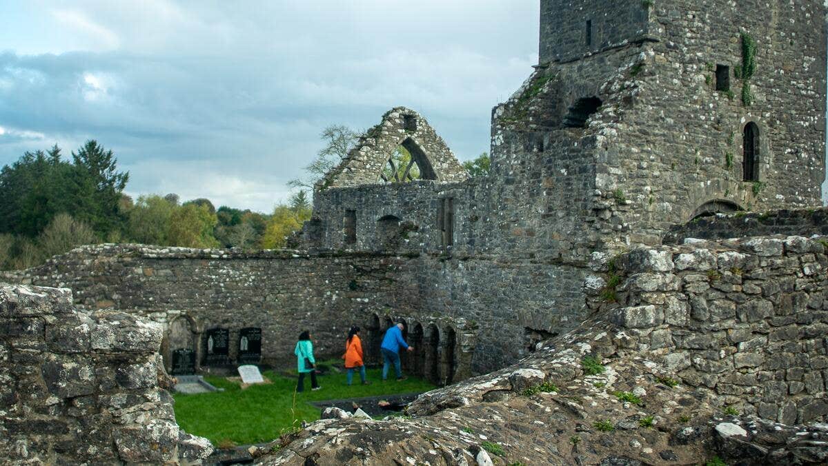 Three people exploring an ecclesiastical site