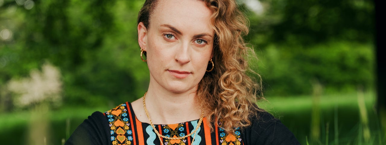 A woman outdoors in tall, green grass