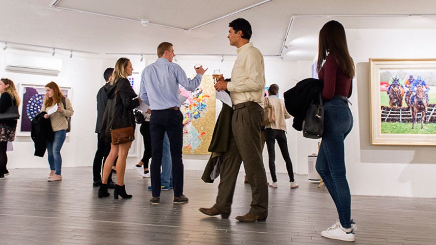 People milling around the gallery exploring the exhibition of works