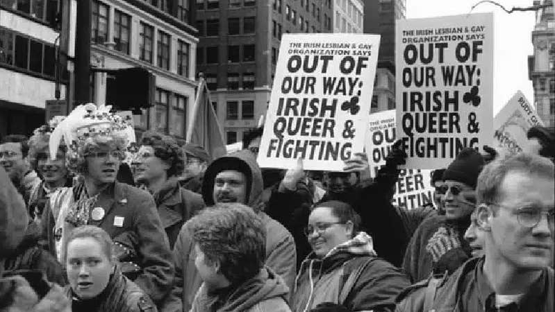 Black and white photo of people in a demonstration holding up signs