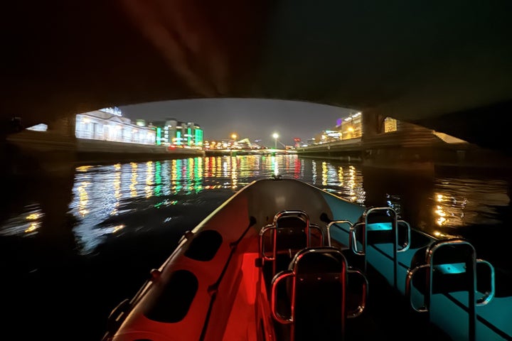 The Customs House comes into view as seen from Irish National Sailing and Powerboat School boat at night with building lit up.