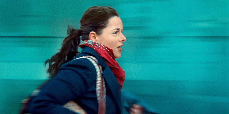 A woman in a coat is running.