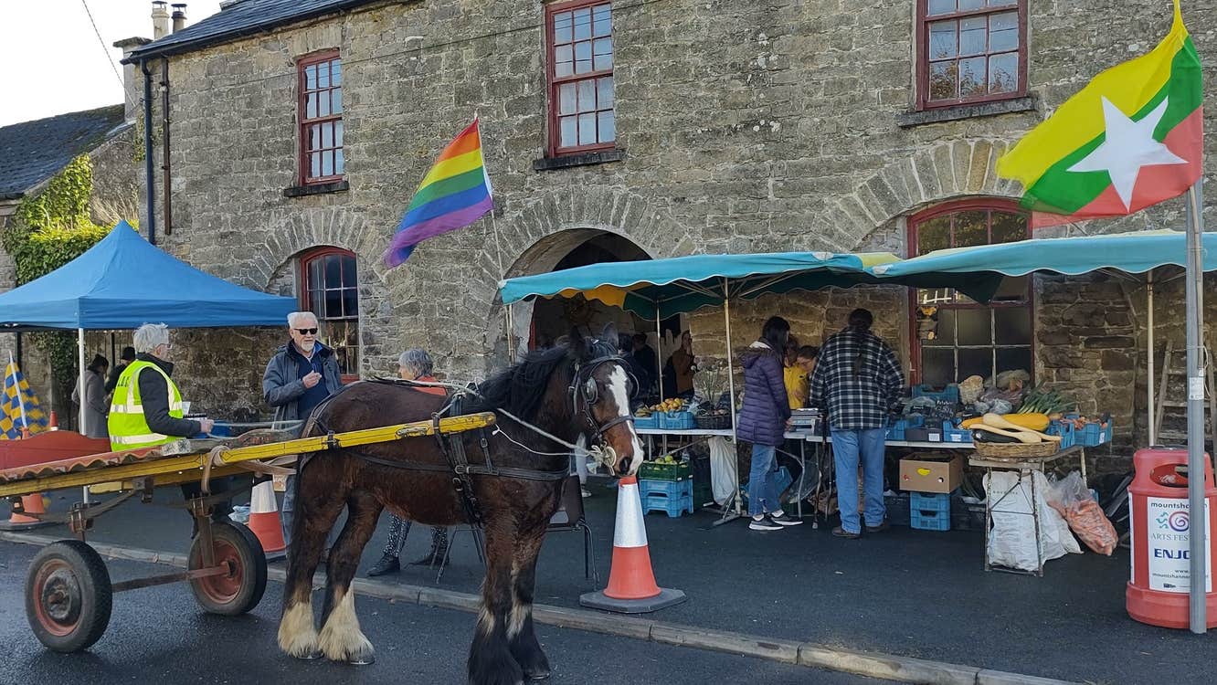 Stone building with two market stalls and a pony and cart outside