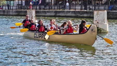 A group together on larger canoe out on the river