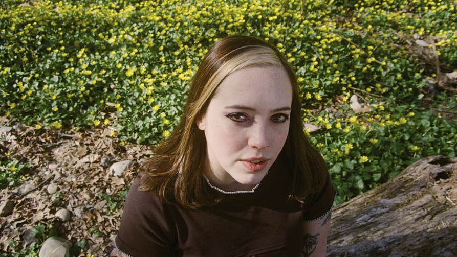 Looking slightly down at a woman in dark top outdoors.