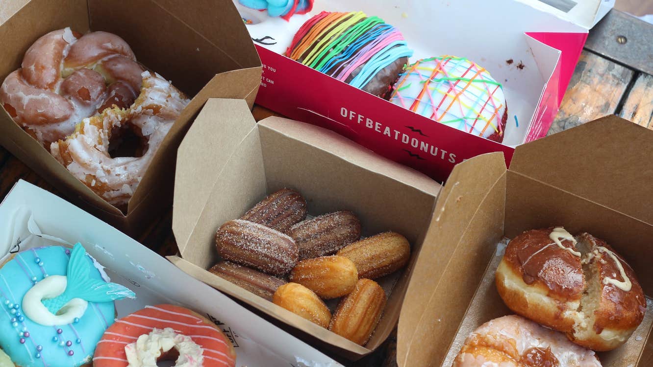 A selection of doughnuts of all shapes and sizes in four takeaway boxes