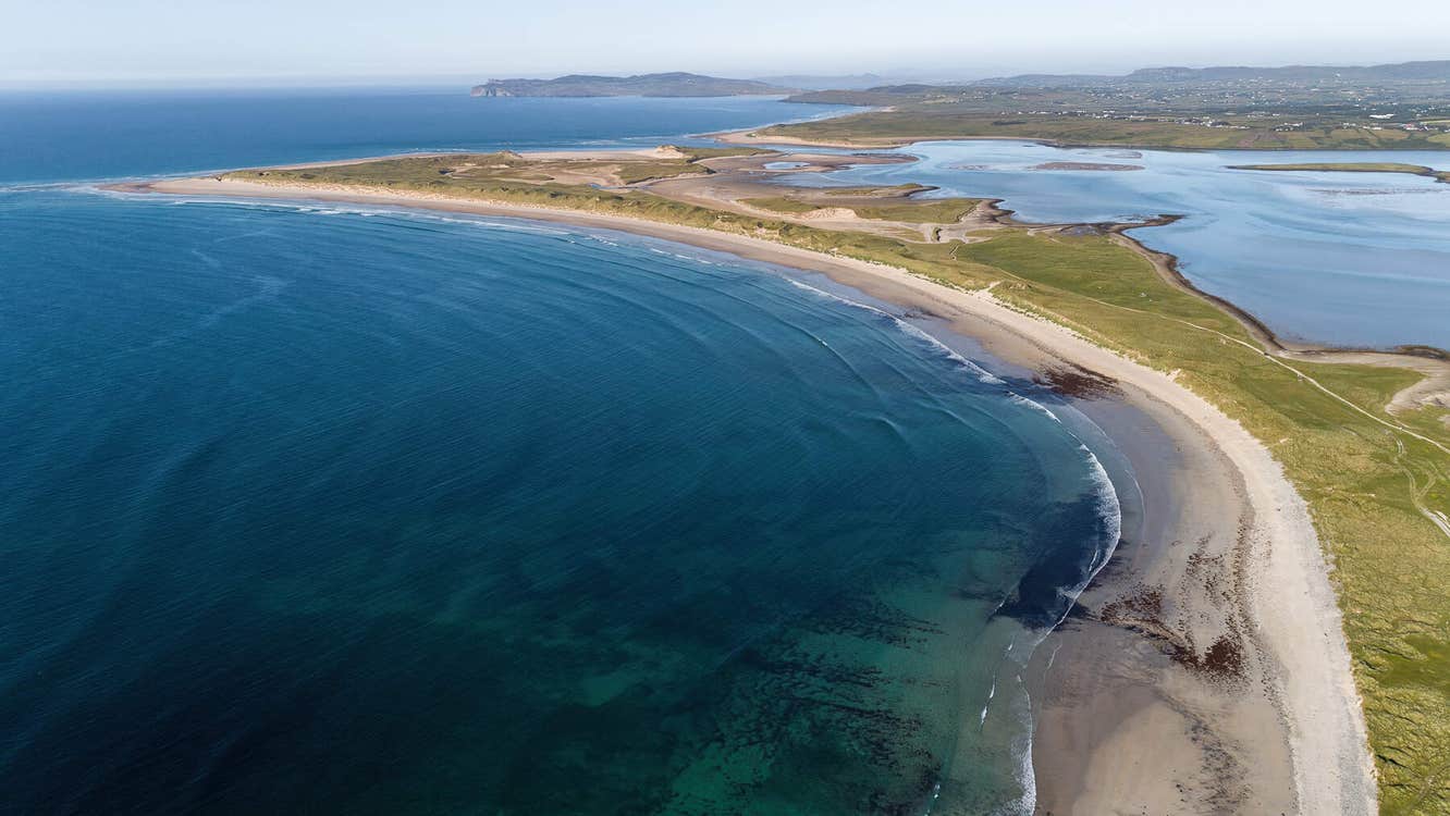 View towards the sea and a headland with mountains in the background