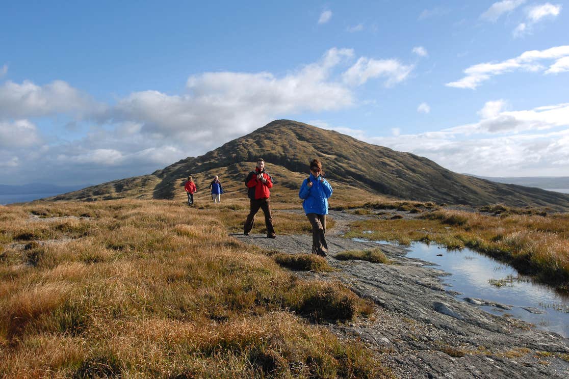 People walking at the base of a mountain on Sheep's Head, Cork