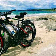 spike island ireland tours Two bikes parked up with Garrettstown Beach and the sea in the background