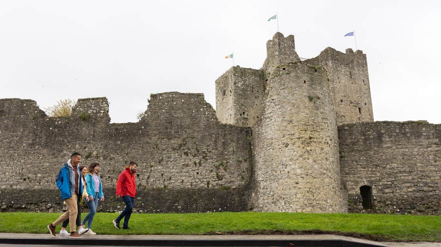 People walking past Trim Castle, Co Meath