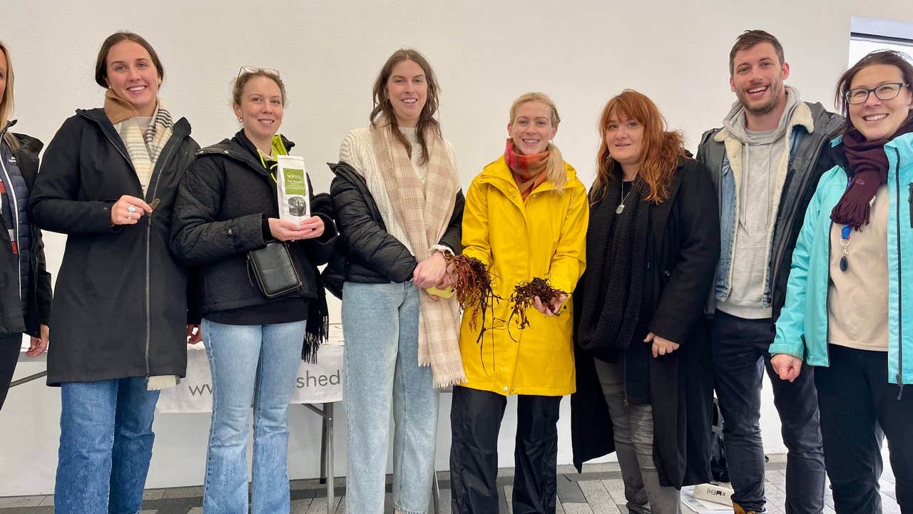 A group of people posing with seaweed and seaweed products