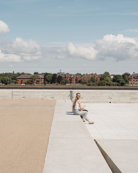 A large cement and brick open area with a partial coastal view