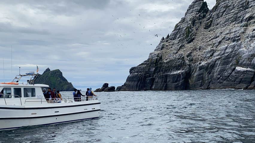 The Skellig Michael Cruises Boat on the sea beside the craggy rocks of Skellig Michael