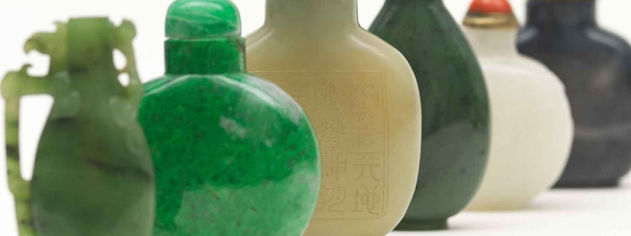 Up close view of line of small different coloured ceramic vessels