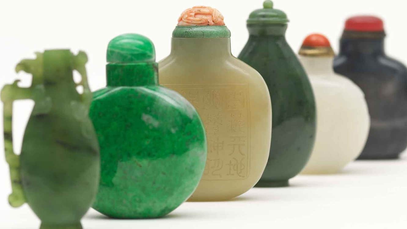 Up close view of line of small different coloured ceramic vessels