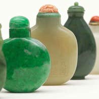 Up close view of line of small different coloured ceramic vessels