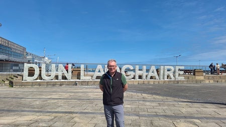 A tour guide posed at the Dun Laoghaire place name sculpture