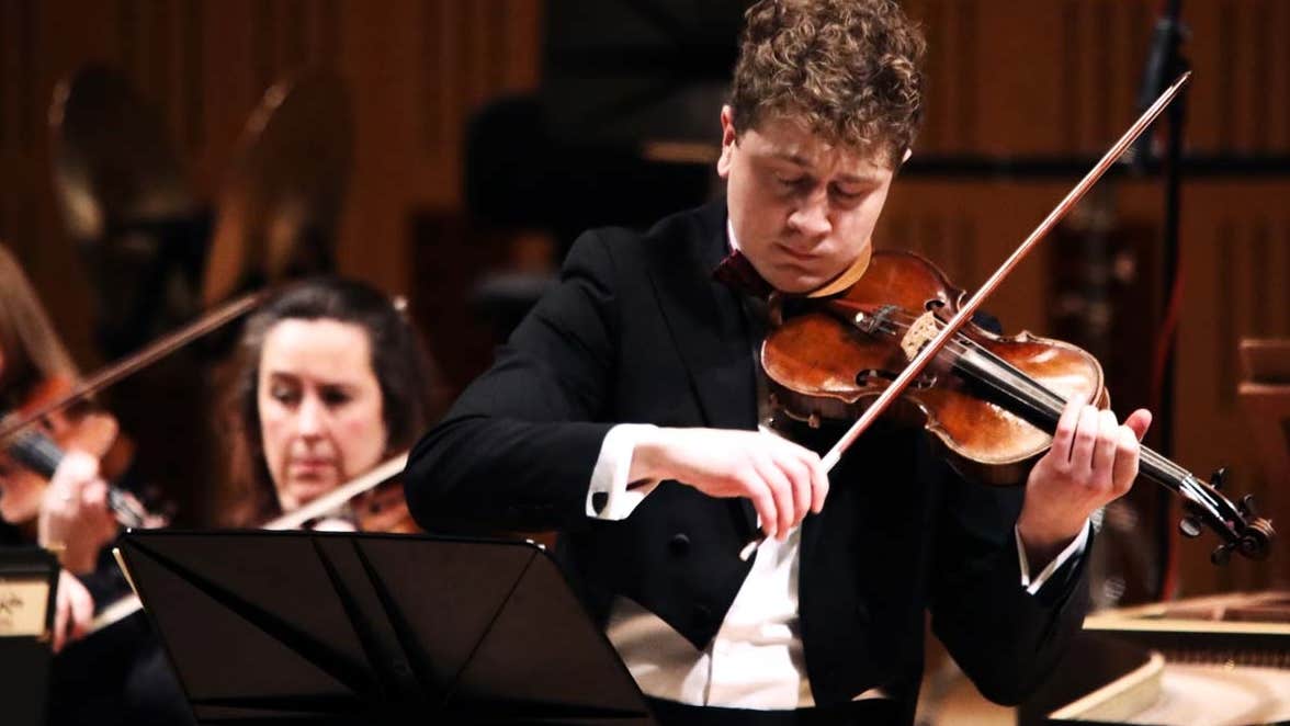 Patrick Rafter playing the violin in concert attire.