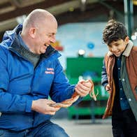 Leahy's Open Farm man laughing while showing a snake to a boy