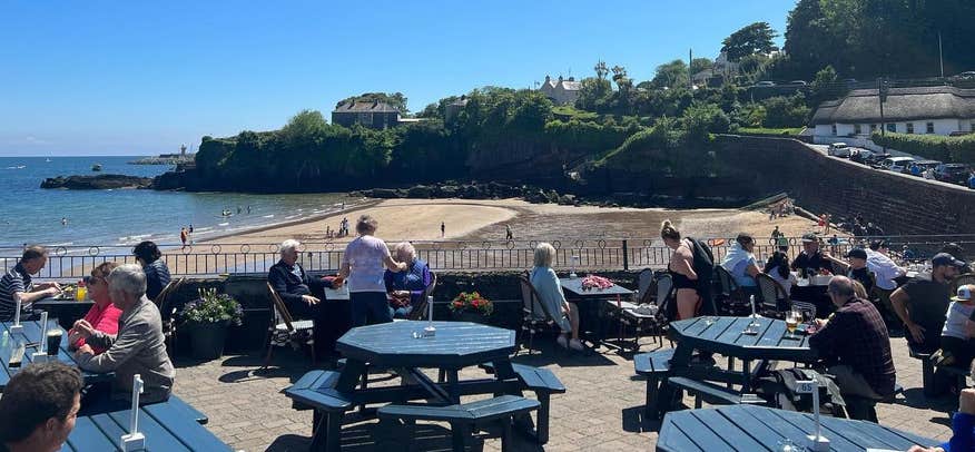 People sitting outside at the Strand Inn in Dunmore East in County Waterford.