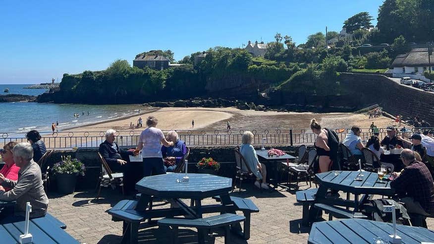 People sitting outside at the Strand Inn in Dunmore East in County Waterford.