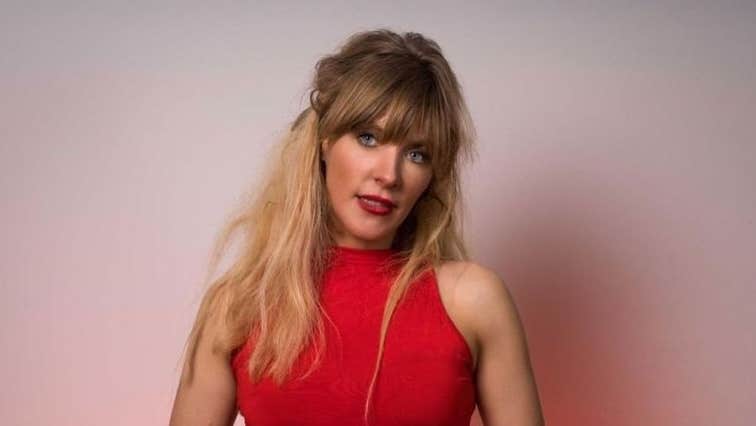 Comedian Aideen McQueen, a woman in red dress holding a mic