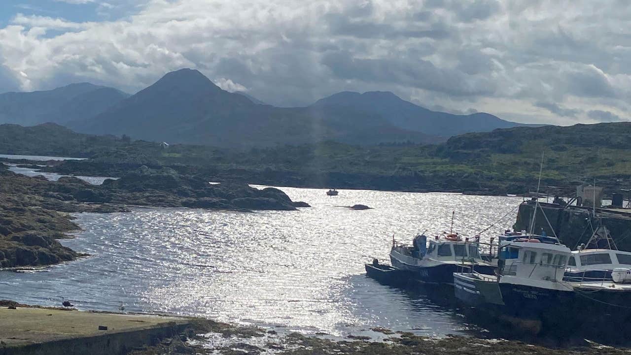 Boats in a small harbour with Connemara mountains in the background