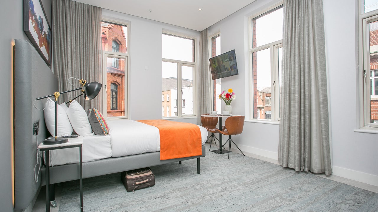 Double bedroom with white and orange sheets