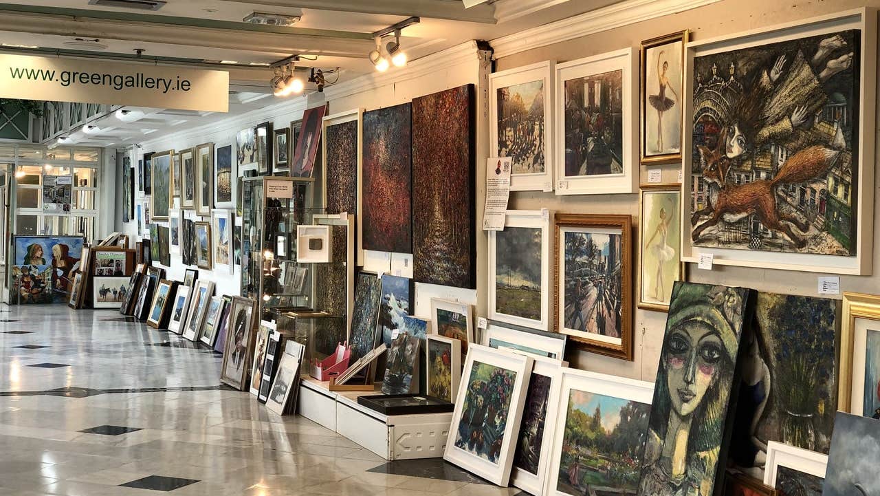 A room with walls full of framed artworks in various sizes