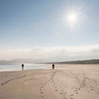 Two people walking on Killahoey Beach in Dunfanaghy, County Donegal