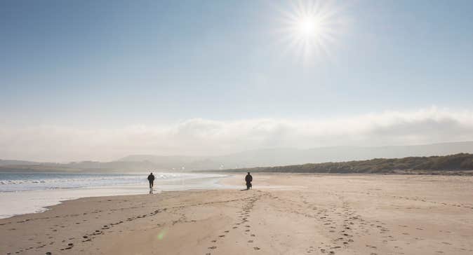 Two people walking on Killahoey Beach in Dunfanaghy, County Donegal