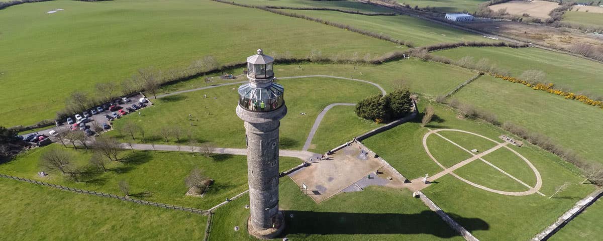 An aerial view of a tall tower with a glass observation platform at the top