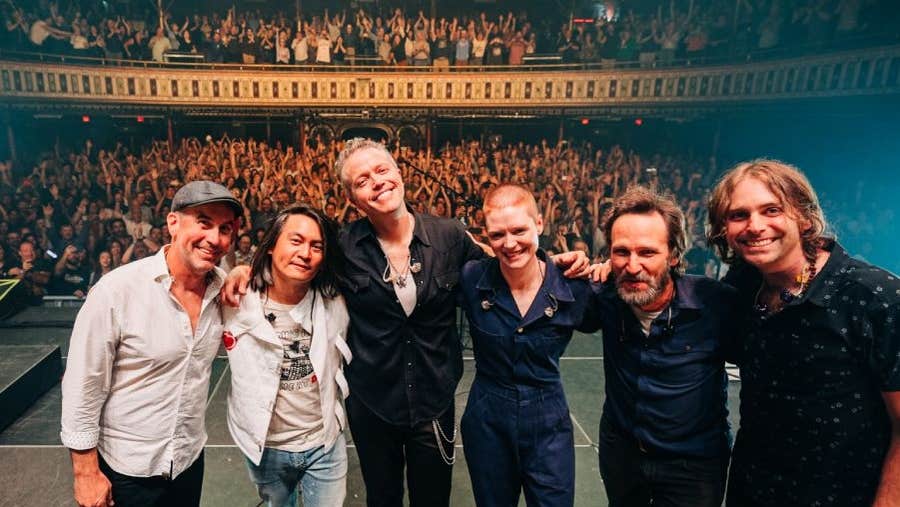 Jason Isbell & The 400 Unit, a line of people smiling on a stage with their back to a waving audience