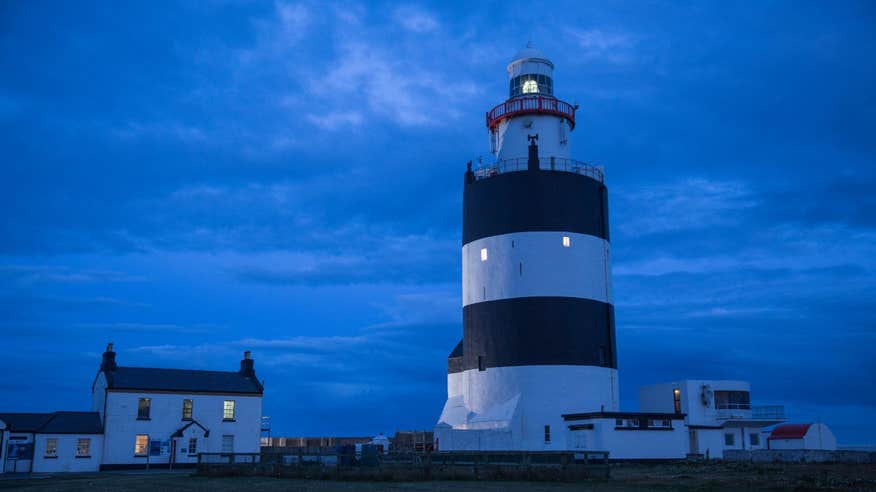 Lighthouse in the evening time beside a house on Hook Head Wexford