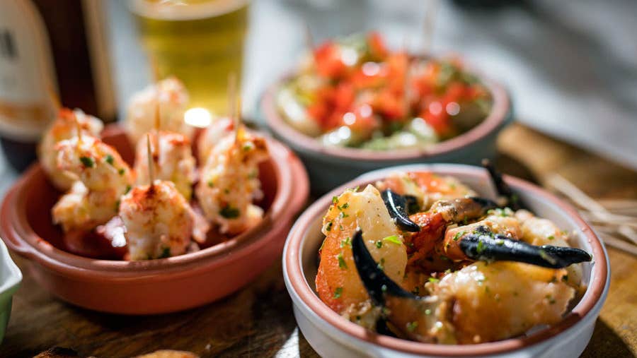 A display of sea food dishes including crab claws and prawns