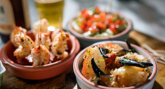 A display of sea food dishes including crab claws and prawns