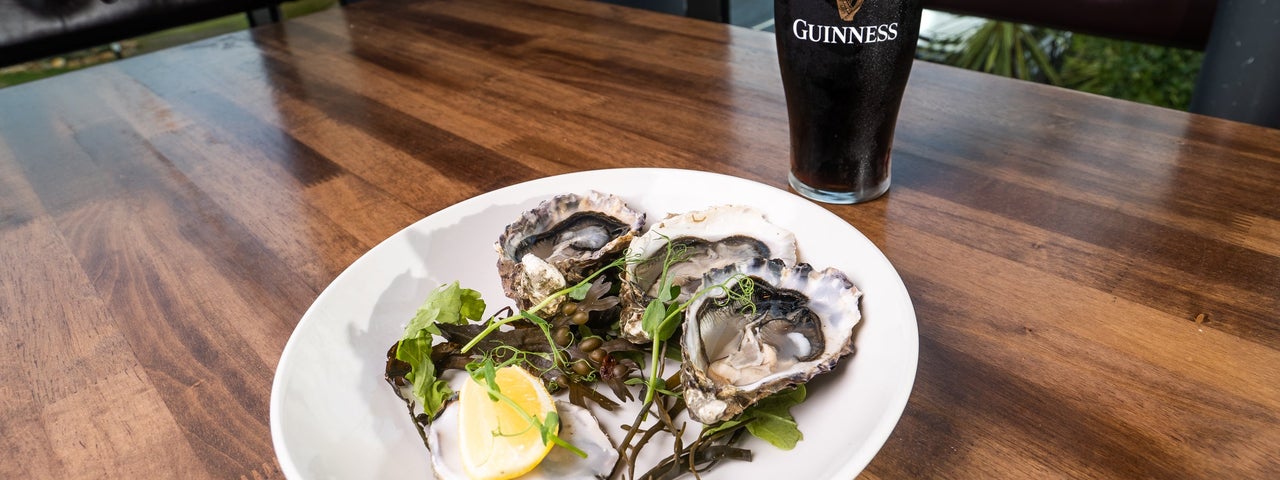 A plate of oysters with a pint of guinness