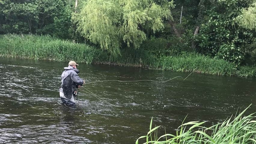A fisherman fly fishing in a river