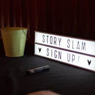 A rectangular light box with slim black writing on white background.