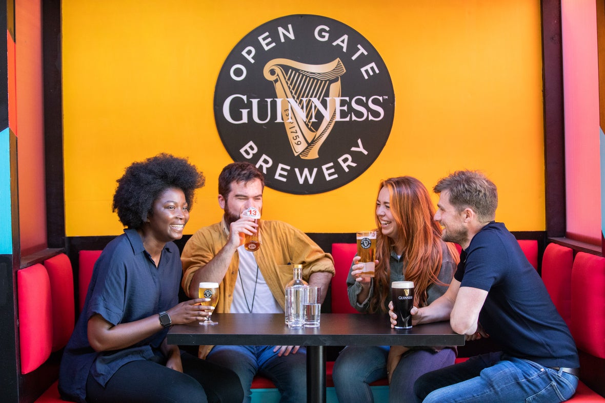 Four people having a drink at the Guinness Open Gate Brewery in Dublin city.