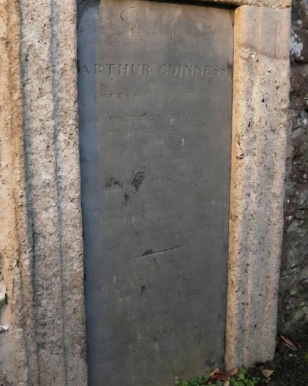 Weathered stone grave marker set into an old stone wall