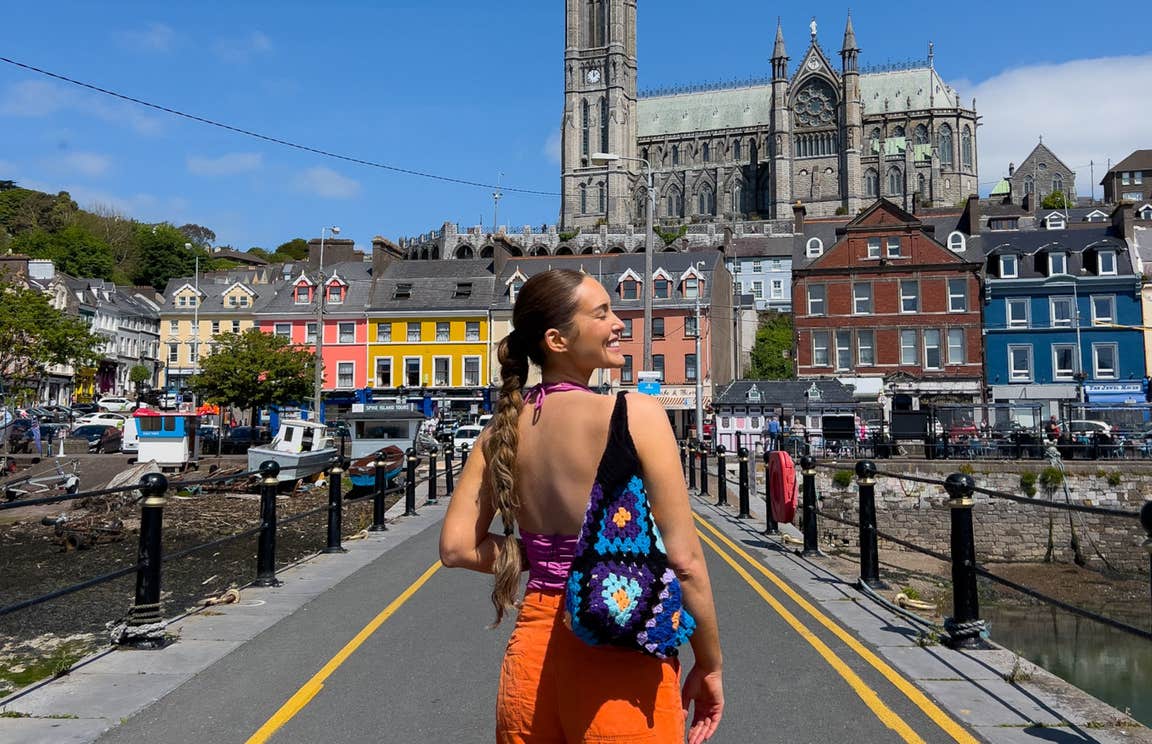A woman smiling with brightly coloured homes behind her.