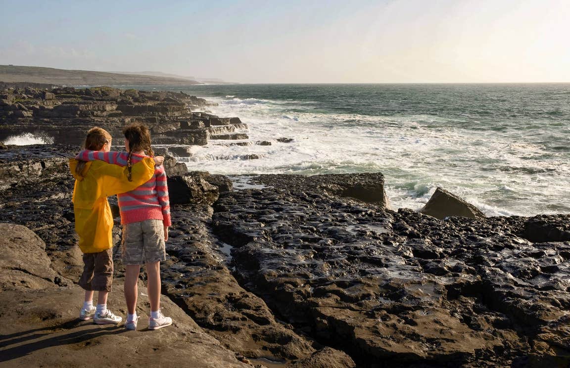 Two young girls looking out at the ocean in The Burren, Co Clare