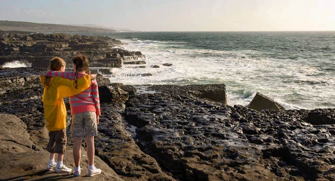 Two young girls looking out at the ocean in The Burren, Co Clare