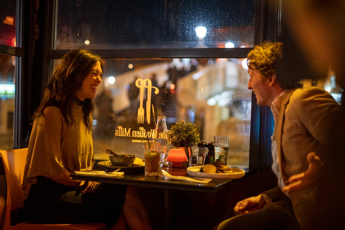 A couple sitting by the window with a view of the Ha'Penny Bridge in Dublin City.