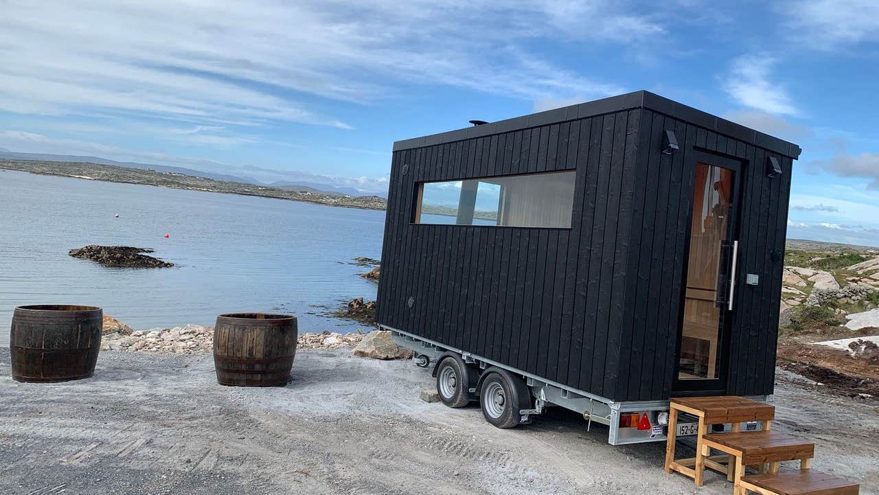 A small sauna and two half barrel seaweed baths beside a sea view