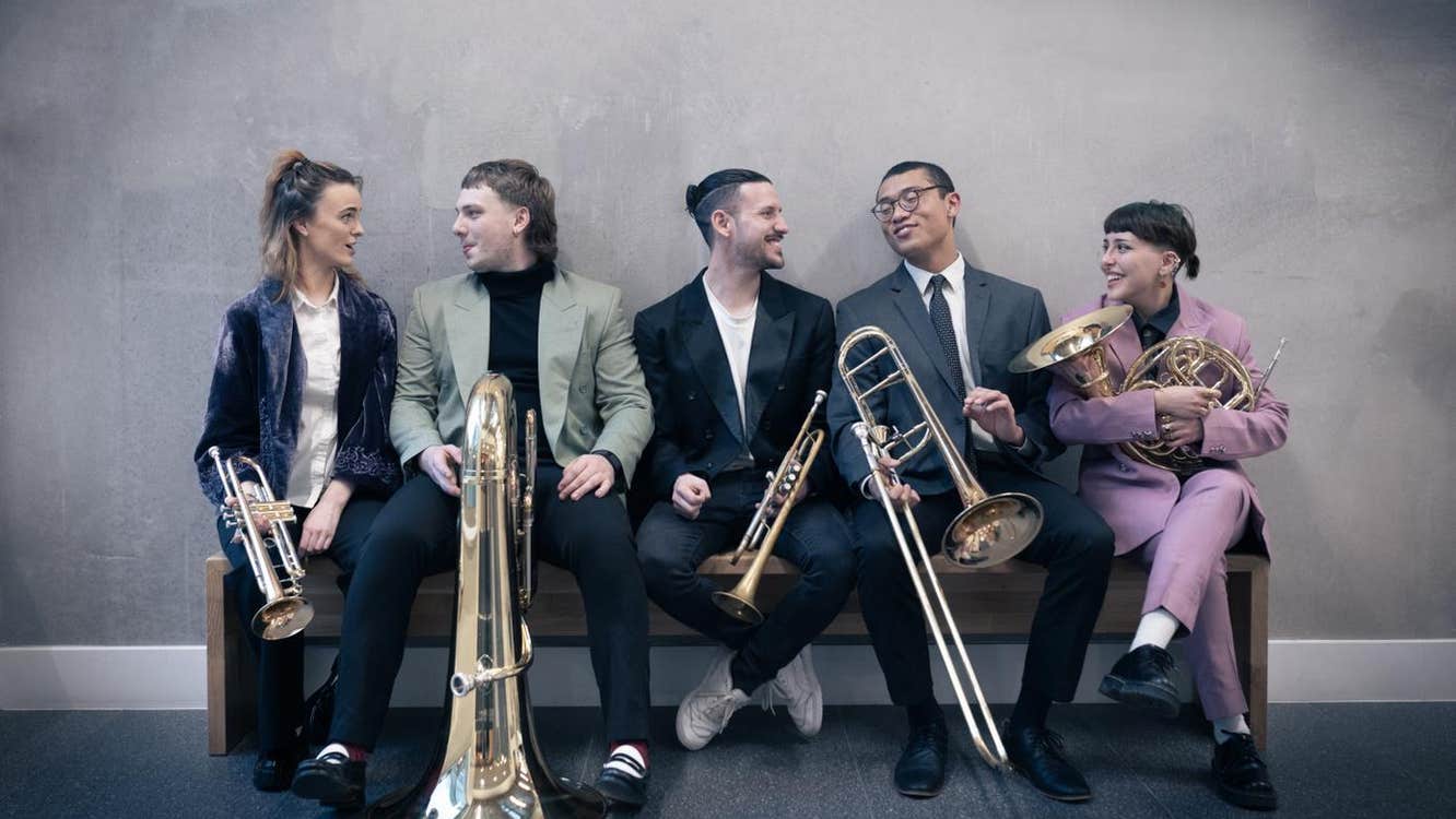 5 young brass musicians with their instruments